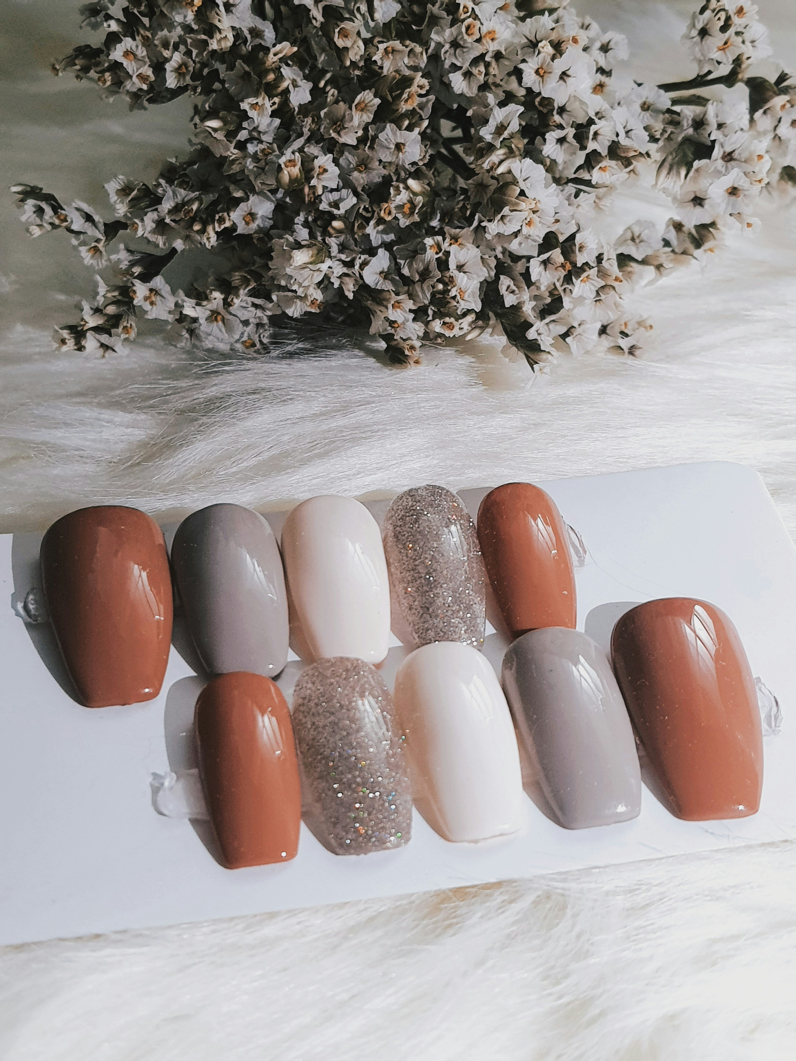 Neutral nail art sample placeholder photographed on a white salon surface